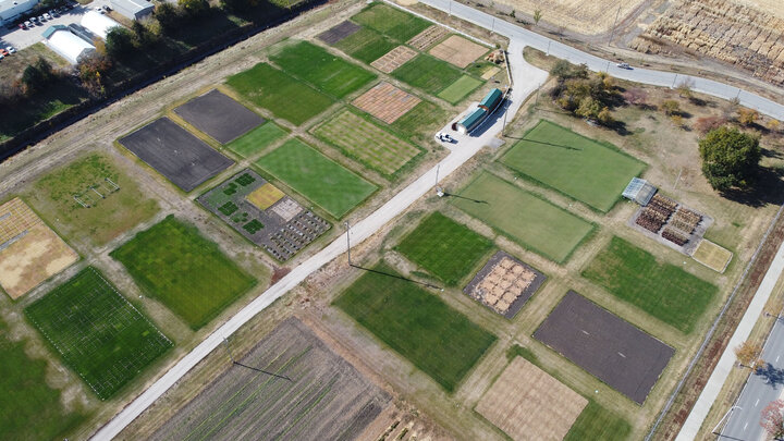 Aerial view of East Campus turfgrass research facility with plots of grass and crops arranged in a grid pattern.