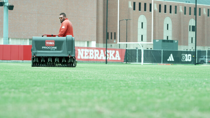 Alex Harter aeriating the newly applied bermudagrass at the Husker Football Practice Fields.